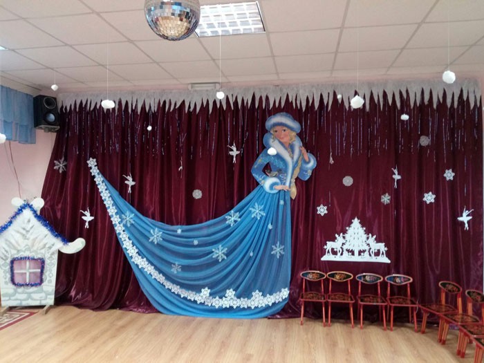 В качестве тематического фона используются 2D-фигурки из текстиля и бумаги. На заднем плане лепят снеговиков, заснеженную деревню или несколько елок